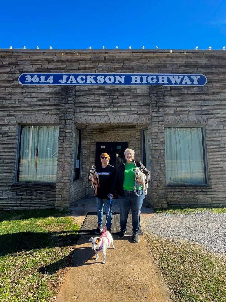 Heather Brown and her wife Janice stand in front of Muscle Shoals, a historic recording studio, with their three dogs