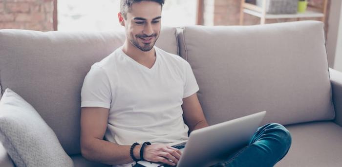 person sitting on a couch working on a laptop