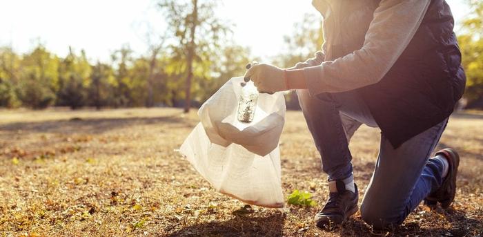 person picking up trash outdoors