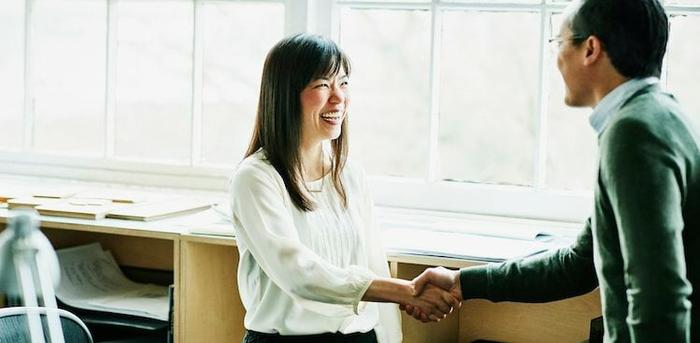 people shaking hands in office