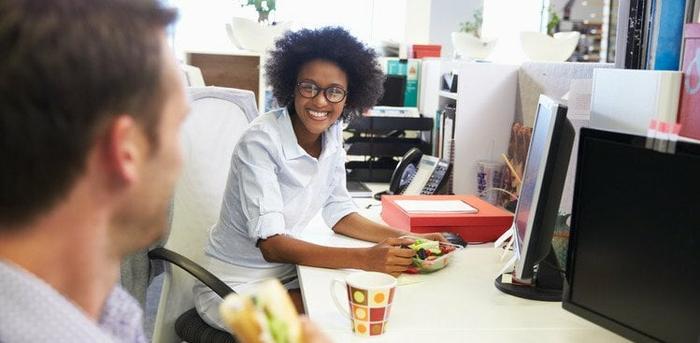 co-workers eating lunch at their desks