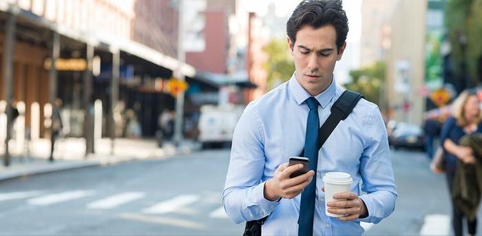 man checking email on way to work