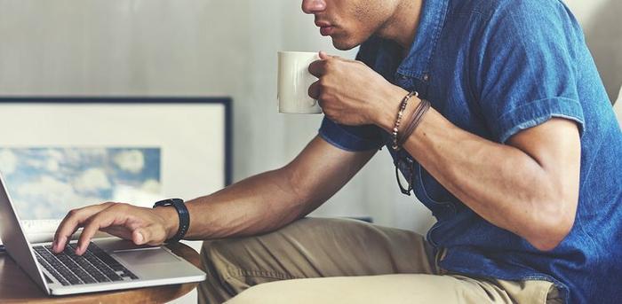 man with coffee on laptop