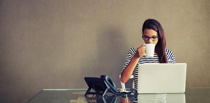 person drinking coffee at laptop