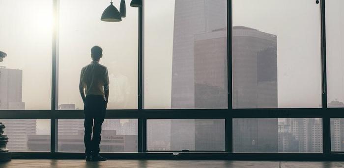 man looking out window