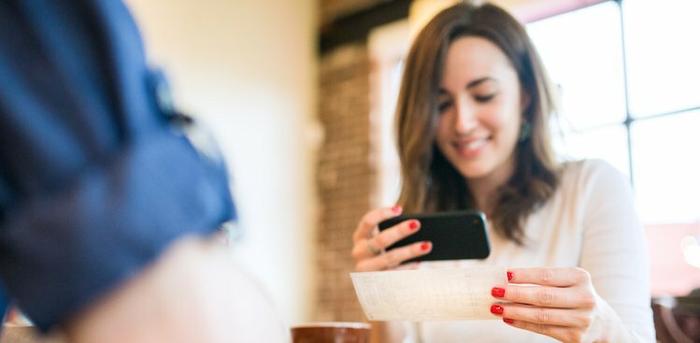 woman scanning her first paycheck with her phone