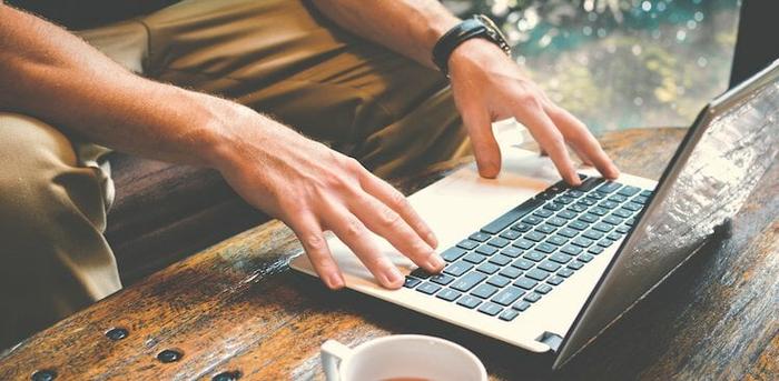 hands of person on laptop