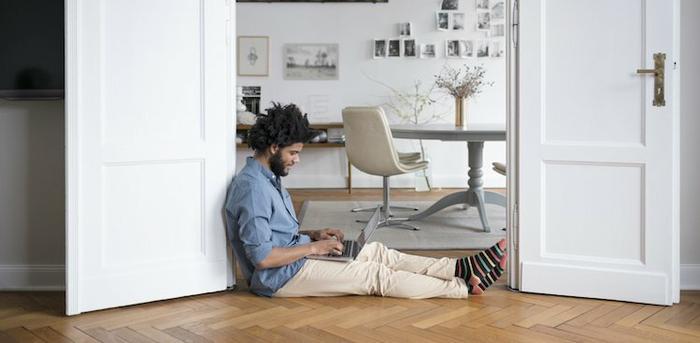 person on laptop on floor