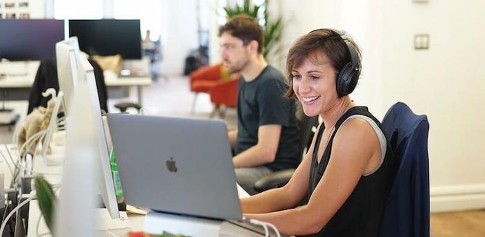 an employee wearing headphones working at Asana's New York City office