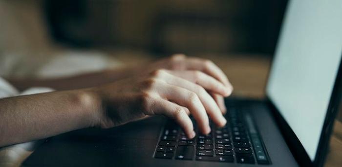 hands typing on computer