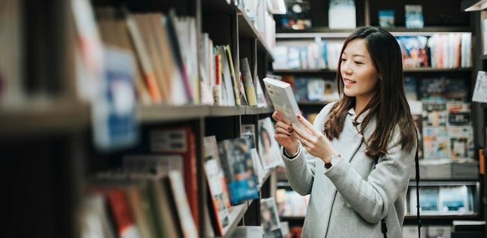 person looking at book in bookstore