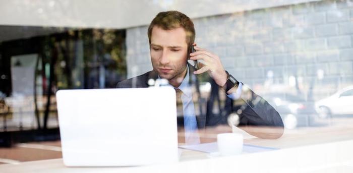 person on the phone looking at computer