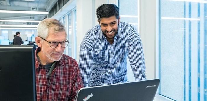 two Klaviyo employees working on a laptop