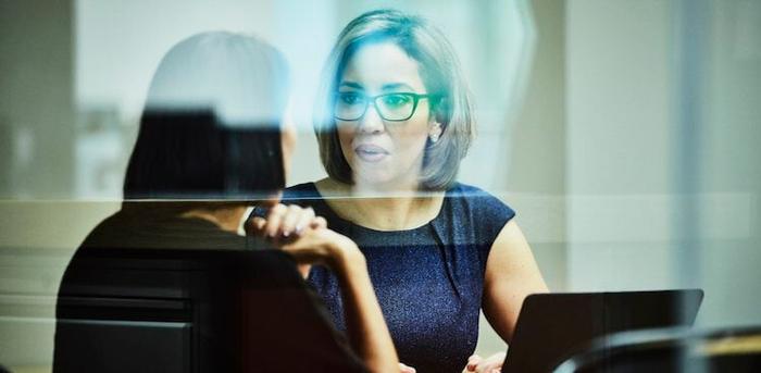 manager talking to employee in conference room