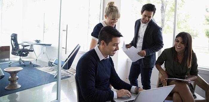 group of colleagues working together with a laptop