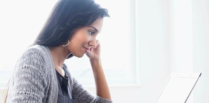 person sitting and looking at their laptop