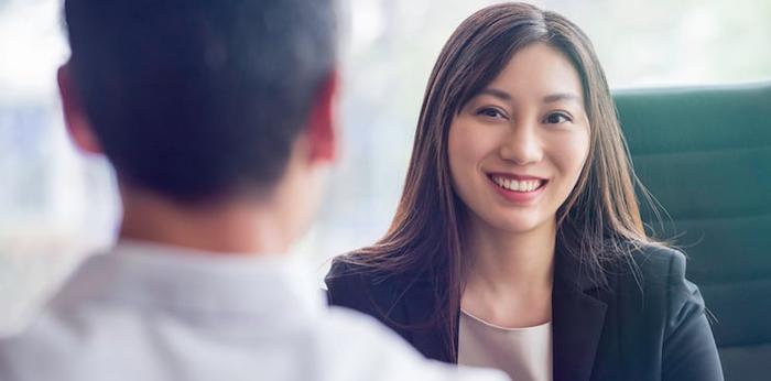 person interviewing for a job with the back of the interviewer's head visible in the foreground