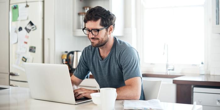 person working at a computer at a kitchen table