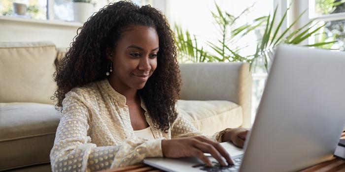 person sitting on floor working on laptop on coffee table