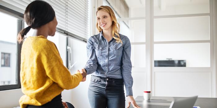 two people shaking hands in conference room before interview