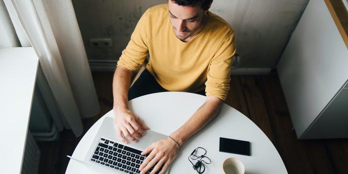 person on laptop at table viewed from above