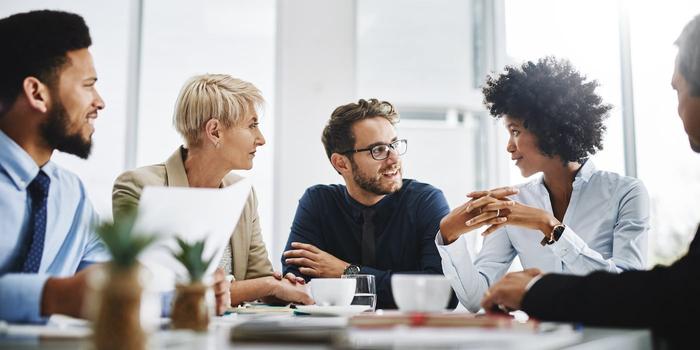 group of coworkers sitting around a table and talking