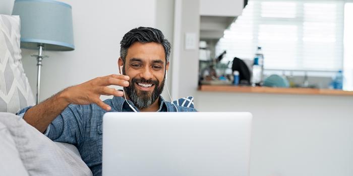 person sitting on a couch doing a video call on a computer