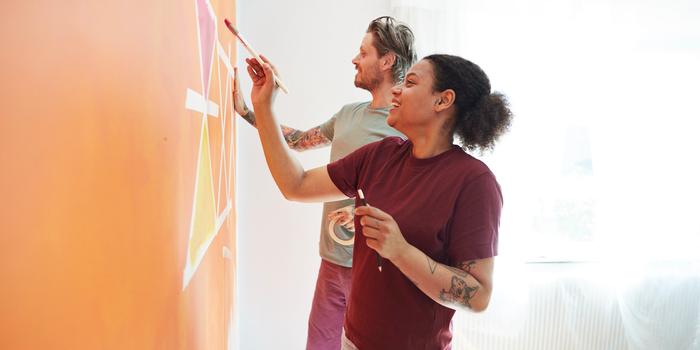 Two people painting on a wall