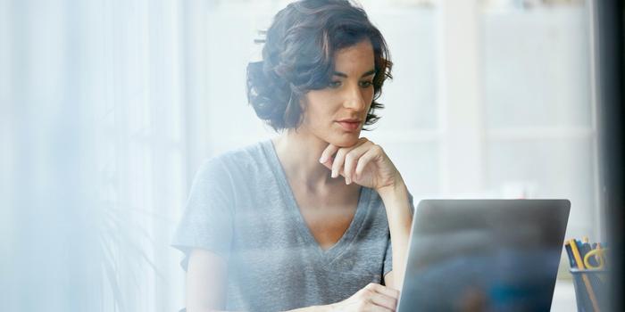 person reading off laptop at table