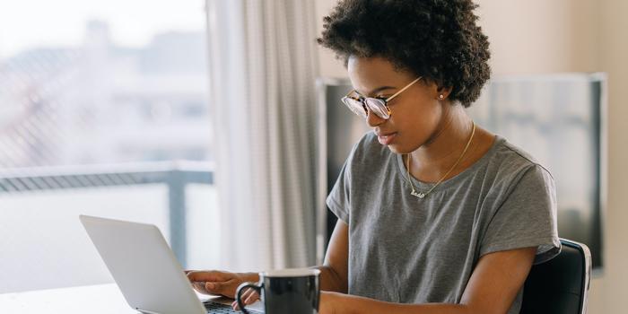 person at table typing on laptop