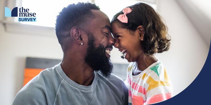 parent and young child laughing with foreheads touching in a white room with a window in the background