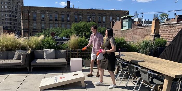 Two Asana employees playing a game of cornhole