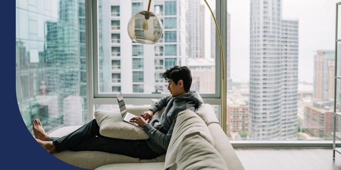 Dropbox employee working from home on his laptop while sitting on his couch.