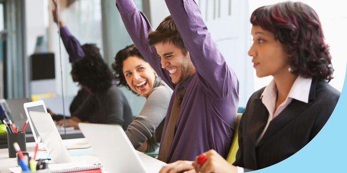 an employee giving side-eye to two of her coworkers who are smiling and laughing next to her at their workstation