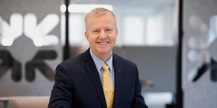 a person in a suit and tie smiling in an office