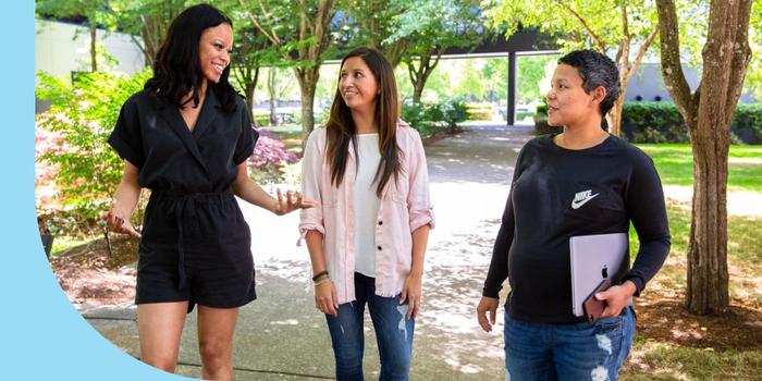 Three Nike employees walking in the garden and having a conversation outside.