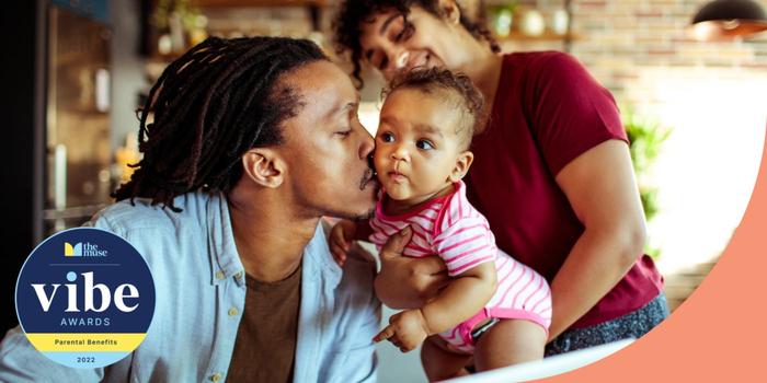 A father kissing his baby as she is held by her mother