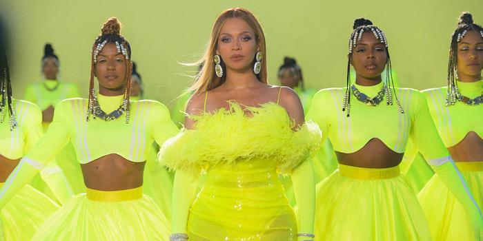 Beyonce in lime green dress with backup dancers in lime green against lime green backdrop at 2022 Oscars