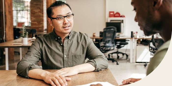 two people sitting at a table during a job interview