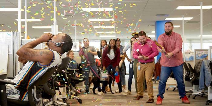 employees celebrating inside the office with confetti