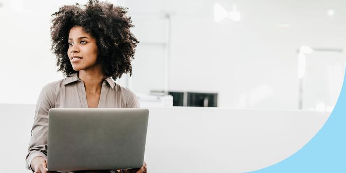 person on a laptop looking off to the side in a white room