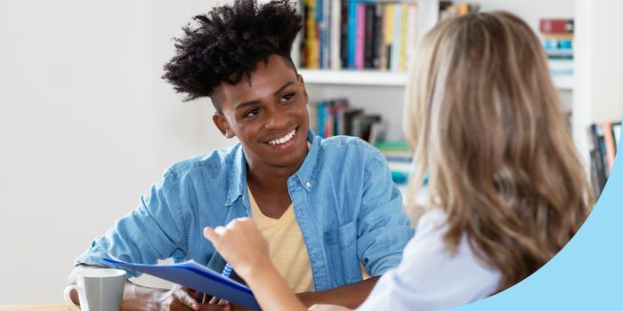 two people in a job interview, one is facing the camera and smiling