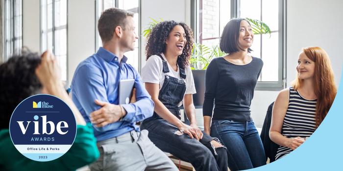 Coworkers smiling and laughing in an office.