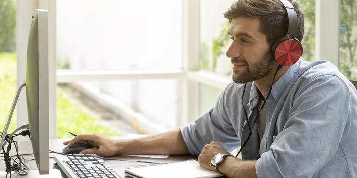 person at computer with headphones