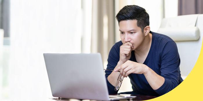 person thinking in front of a laptop