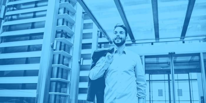 person walking out of an office building looking relaxed and happy after quitting with blue filter over image