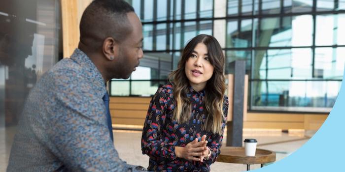 two people talking in a windowed atrium during a job interview