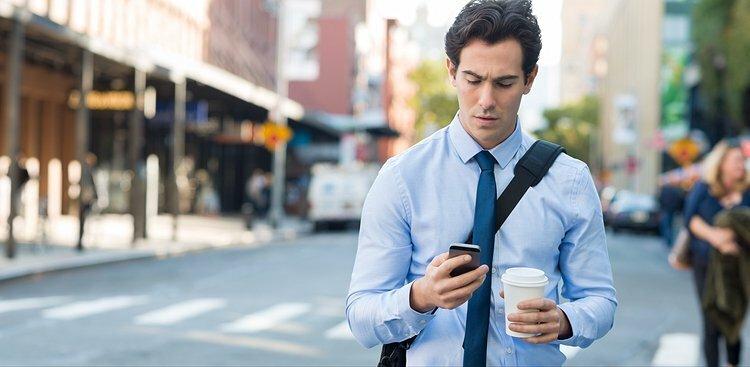 man checking email on way to work