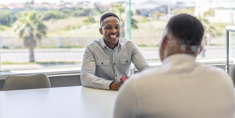 person smiling at a job interview in a conference room with window in the background