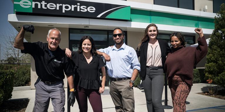 group of five employees standing in front of an Enterprise branch in Valencia, CA